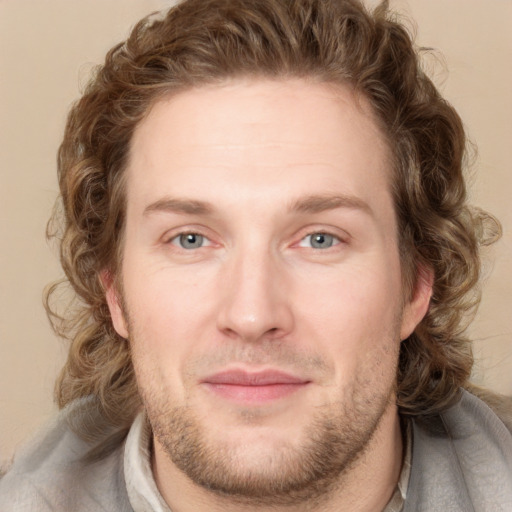 Joyful white young-adult male with short  brown hair and blue eyes