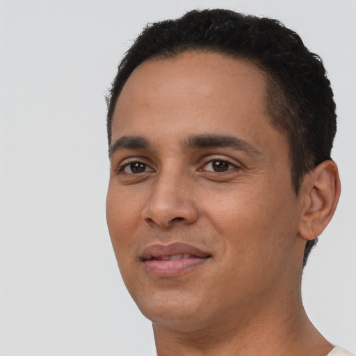 Joyful latino young-adult male with short  black hair and brown eyes
