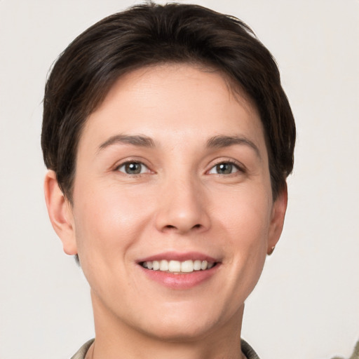 Joyful white young-adult female with short  brown hair and grey eyes