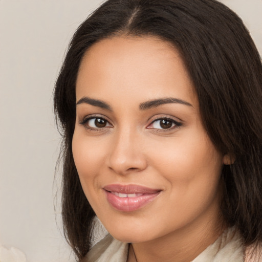 Joyful latino young-adult female with long  brown hair and brown eyes