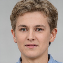 Joyful white young-adult male with short  brown hair and grey eyes