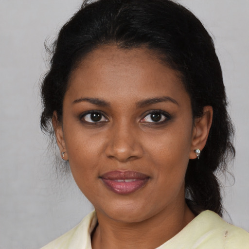 Joyful black young-adult female with medium  brown hair and brown eyes