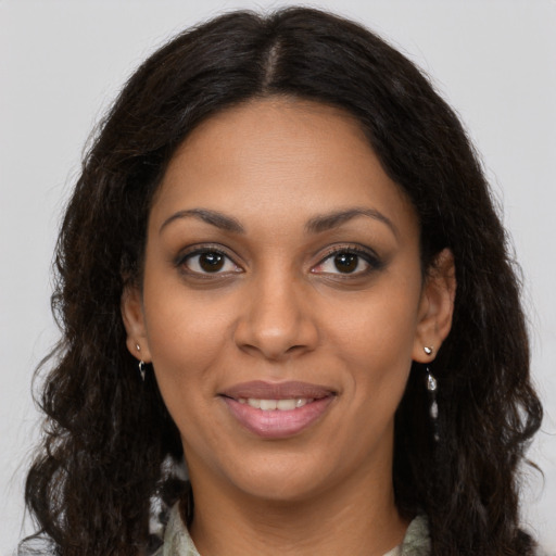 Joyful black young-adult female with long  brown hair and brown eyes
