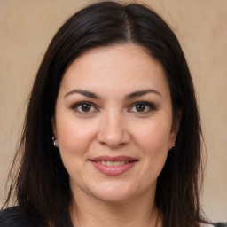 Joyful white young-adult female with long  brown hair and brown eyes