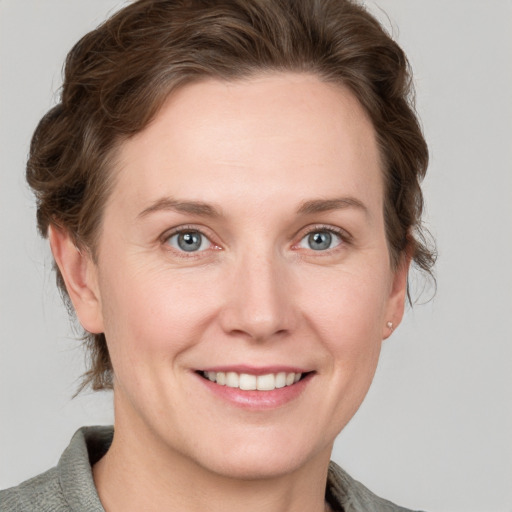 Joyful white adult female with medium  brown hair and grey eyes