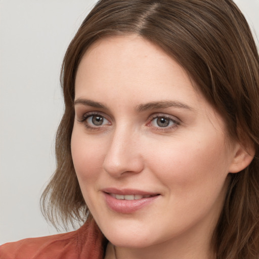 Joyful white young-adult female with long  brown hair and grey eyes