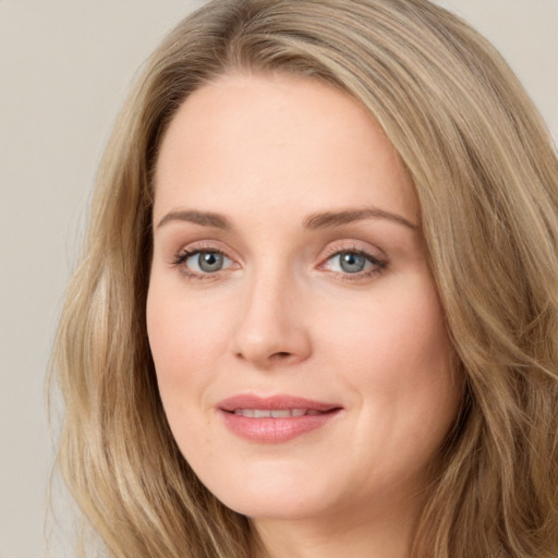 Joyful white young-adult female with long  brown hair and blue eyes