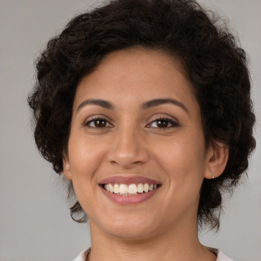 Joyful latino young-adult female with medium  brown hair and brown eyes