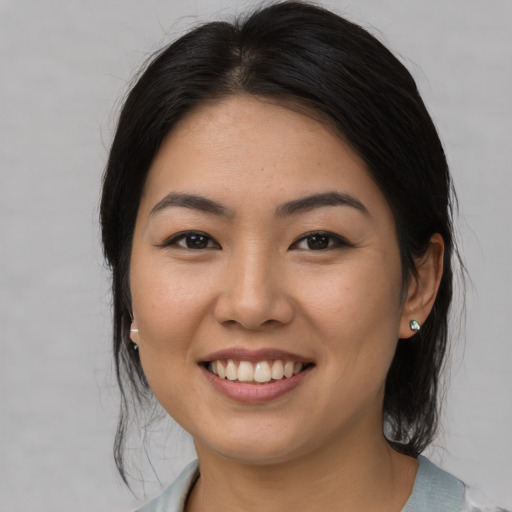 Joyful asian young-adult female with medium  black hair and brown eyes