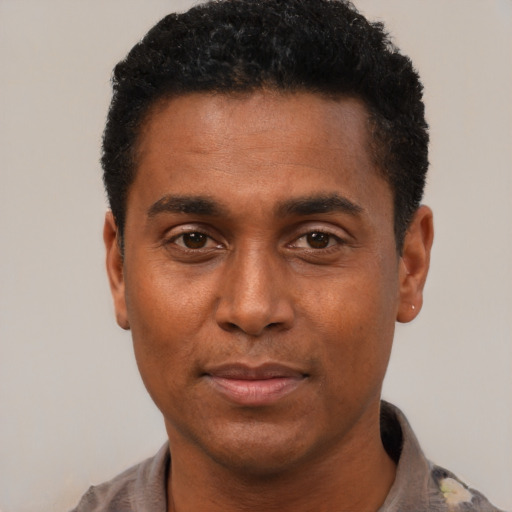 Joyful black adult male with short  black hair and brown eyes
