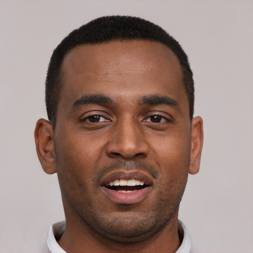 Joyful black young-adult male with short  brown hair and brown eyes