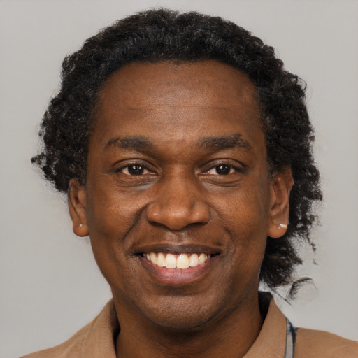 Joyful black adult male with short  black hair and brown eyes
