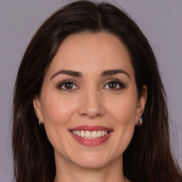 Joyful white young-adult female with long  brown hair and brown eyes