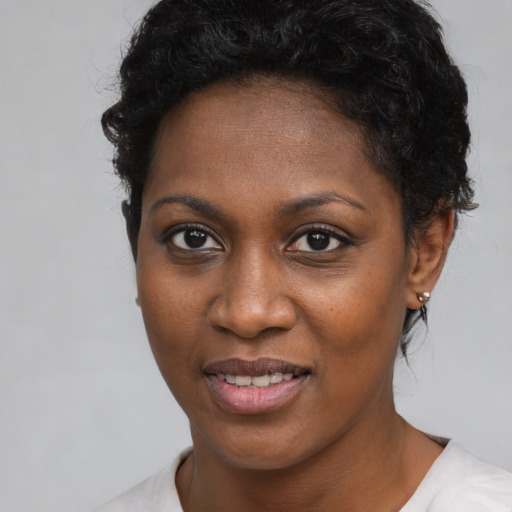 Joyful black young-adult female with short  black hair and brown eyes