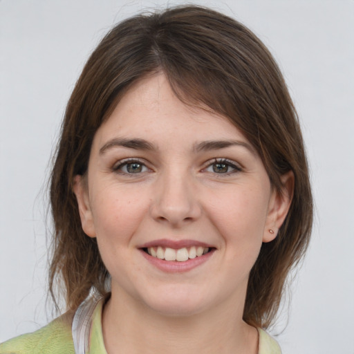 Joyful white young-adult female with medium  brown hair and grey eyes