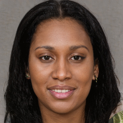 Joyful black young-adult female with long  brown hair and brown eyes