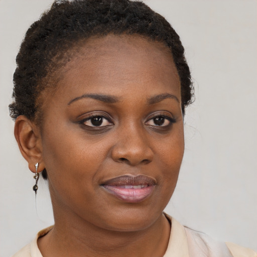 Joyful black young-adult female with short  brown hair and brown eyes