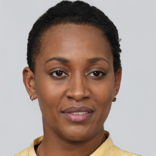 Joyful black young-adult female with short  black hair and brown eyes