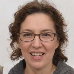 Joyful white adult female with medium  brown hair and blue eyes