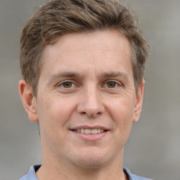 Joyful white adult male with short  brown hair and grey eyes