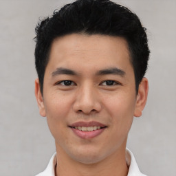 Joyful asian young-adult male with short  black hair and brown eyes