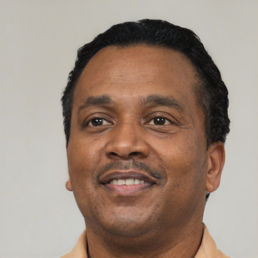 Joyful black adult male with short  black hair and brown eyes