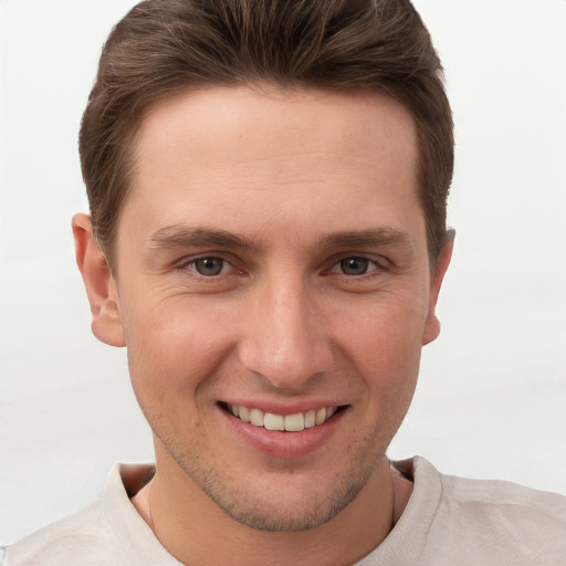 Joyful white young-adult male with short  brown hair and grey eyes