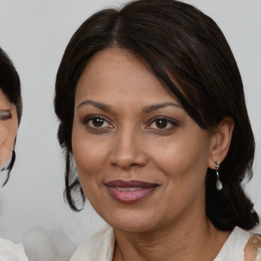 Joyful latino young-adult female with medium  brown hair and brown eyes