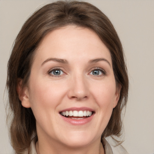 Joyful white young-adult female with medium  brown hair and grey eyes