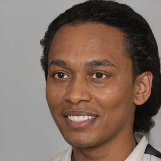 Joyful black adult male with short  black hair and brown eyes