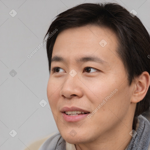 Joyful asian young-adult male with short  brown hair and brown eyes