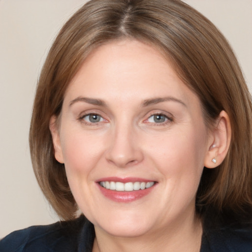 Joyful white adult female with medium  brown hair and grey eyes