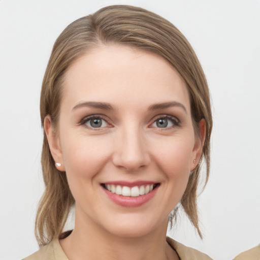 Joyful white young-adult female with medium  brown hair and grey eyes