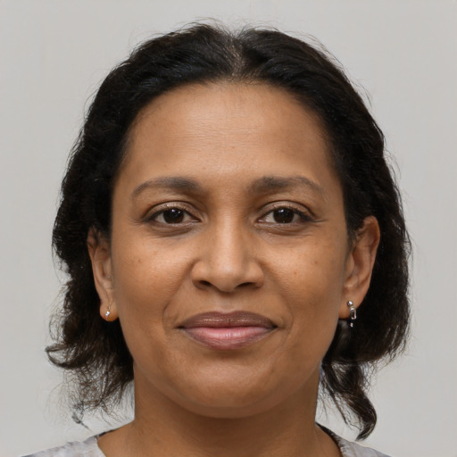 Joyful black adult female with medium  brown hair and brown eyes