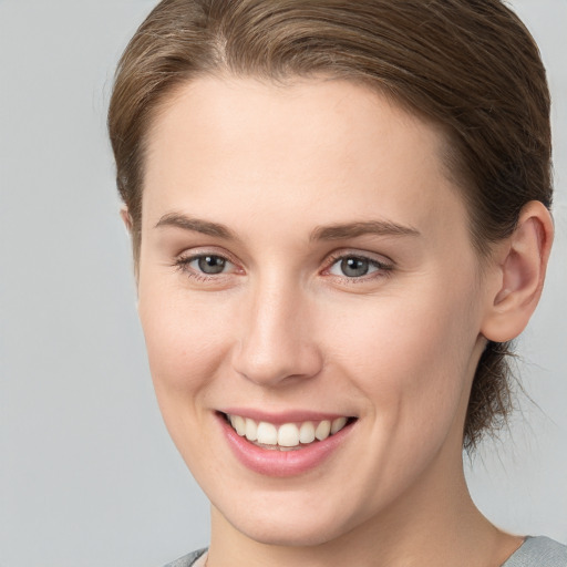 Joyful white young-adult female with short  brown hair and grey eyes