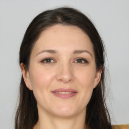 Joyful white adult female with long  brown hair and brown eyes