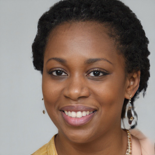 Joyful black young-adult female with long  brown hair and brown eyes