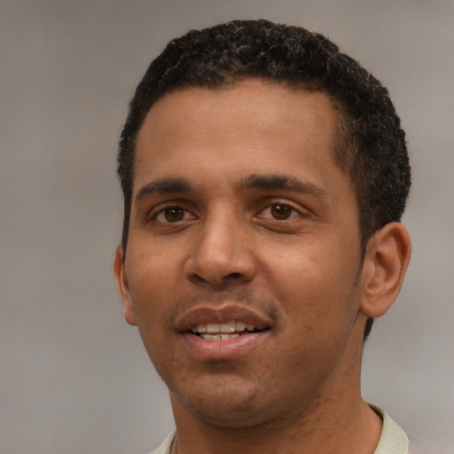 Joyful black young-adult male with short  black hair and brown eyes