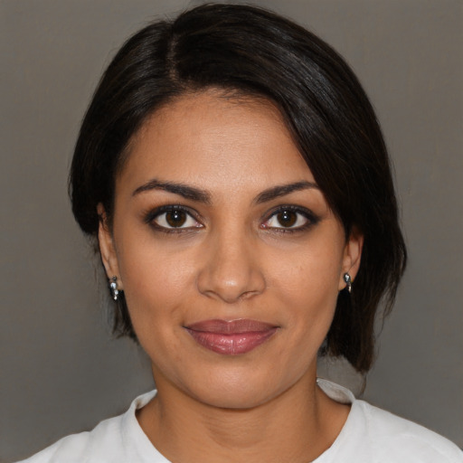 Joyful latino young-adult female with medium  brown hair and brown eyes