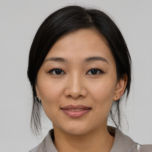 Joyful asian young-adult female with medium  black hair and brown eyes