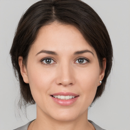 Joyful white young-adult female with medium  brown hair and brown eyes