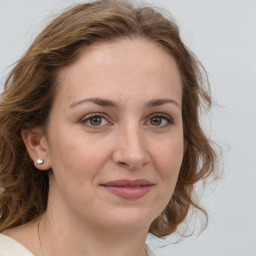 Joyful white young-adult female with medium  brown hair and green eyes