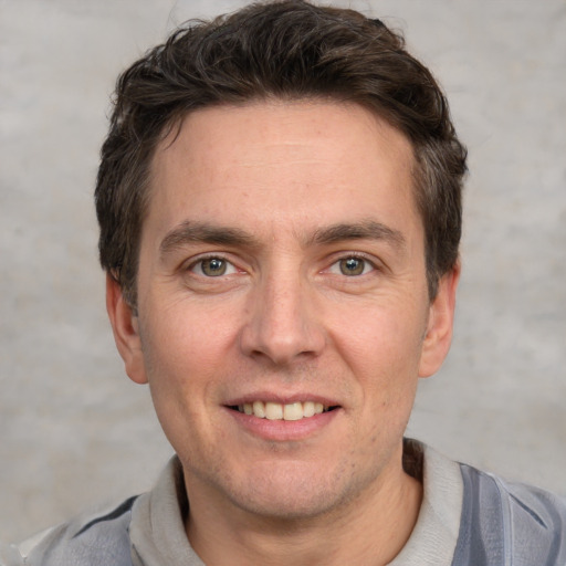 Joyful white adult male with short  brown hair and grey eyes