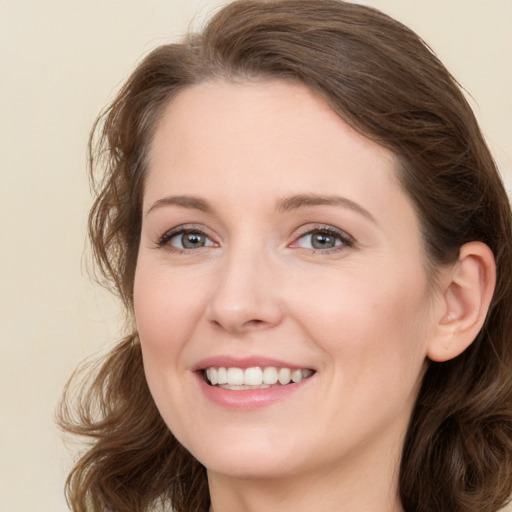 Joyful white young-adult female with long  brown hair and green eyes