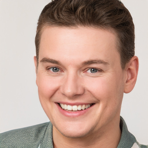 Joyful white young-adult male with short  brown hair and grey eyes