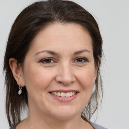 Joyful white adult female with medium  brown hair and grey eyes