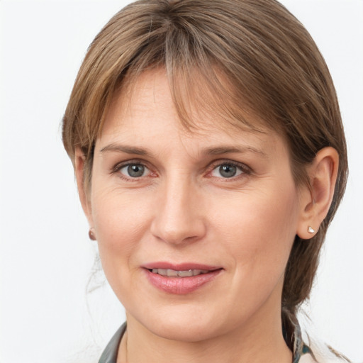 Joyful white young-adult female with medium  brown hair and grey eyes