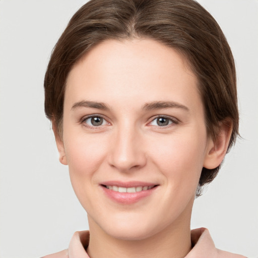 Joyful white young-adult female with short  brown hair and grey eyes