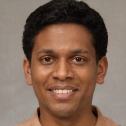 Joyful latino young-adult male with short  black hair and brown eyes