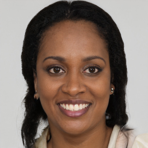 Joyful black young-adult female with long  black hair and brown eyes